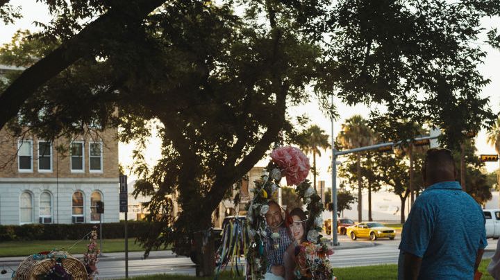 UVALDE, TX - JUNE 25: A couple from the nearby town of Del Rio, TX pays their respects at a memorial for the victims of the mass shooting at Robb Elementary School on June 25, 2022 in Uvalde, Texas. The Uvalde community is marking one month since the deadly shooting where 19 students and 2 teachers were killed. (Photo by Jordan Vonderhaar/Getty Images)