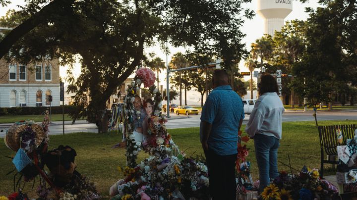UVALDE, TX - JUNE 25: A couple from the nearby town of Del Rio, TX pays their respects at a memorial for the victims of the mass shooting at Robb Elementary School on June 25, 2022 in Uvalde, Texas. The Uvalde community is marking one month since the deadly shooting where 19 students and 2 teachers were killed. (Photo by Jordan Vonderhaar/Getty Images)
