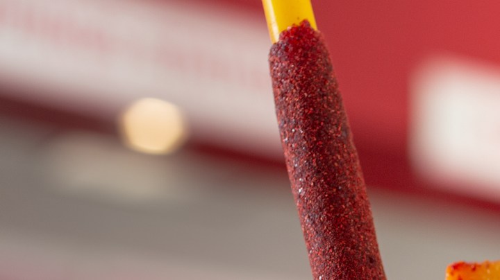 A view of a mangonada drink, in a restaurant interior setting.