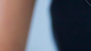 Girl and her sister baking a cake, decorating cake with fresh cream and raspberries at kitchen table, cropped - stock photo