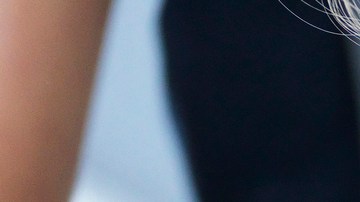 Girl and her sister baking a cake, decorating cake with fresh cream and raspberries at kitchen table, cropped - stock photo