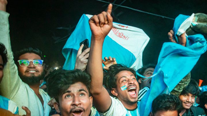 Football fans in Bangladesh celebrate after Argentina players scored a goal as they watch the Qatar 2022 World Cup Group C football match between Argentina and Poland on a big screen, the Dhaka University area, on December 1, 2022.