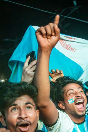 Football fans in Bangladesh celebrate after Argentina players scored a goal as they watch the Qatar 2022 World Cup Group C football match between Argentina and Poland on a big screen, the Dhaka University area, on December 1, 2022.
