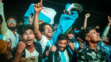 Football fans in Bangladesh celebrate after Argentina players scored a goal as they watch the Qatar 2022 World Cup Group C football match between Argentina and Poland on a big screen, the Dhaka University area, on December 1, 2022.