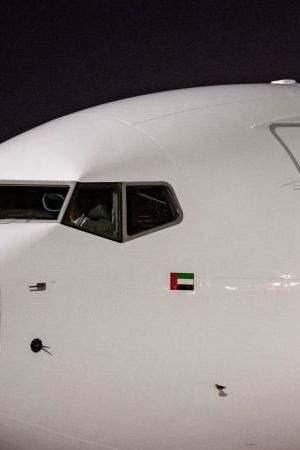 Members of the Argentinian team peer out from the windows on their plane adorned with a picture of Argentina's forward Lionel Messi and teammates as the team arrives at the Hamad International Airport in Doha on November 17, 2022, ahead of the Qatar 2022 World Cup football tournament. (Photo by Odd ANDERSEN / AFP) (Photo by ODD ANDERSEN/AFP via Getty Images)