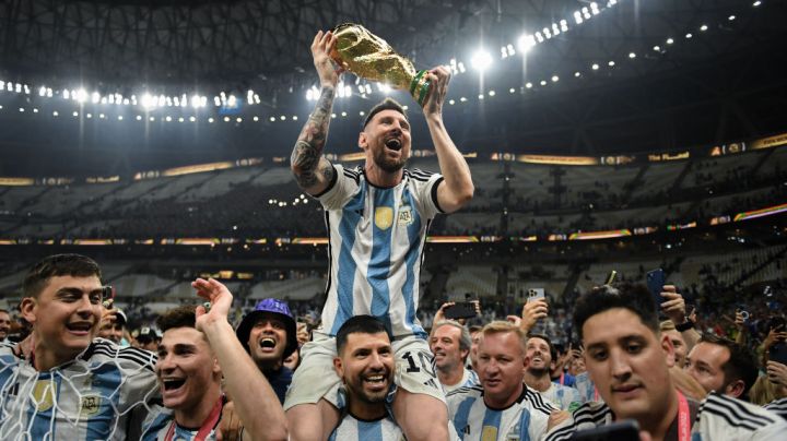 LUSAIL CITY, QATAR - DECEMBER 18: Lionel Messi of Argentina celebrates with the FIFA World Cup Qatar 2022 Winner's Trophy on Sergio 'Kun' Aguero's shoulders after the team's victory during the FIFA World Cup Qatar 2022 Final match between Argentina and France at Lusail Stadium on December 18, 2022 in Lusail City, Qatar. (Photo by David Ramos - FIFA/FIFA via Getty Images)
