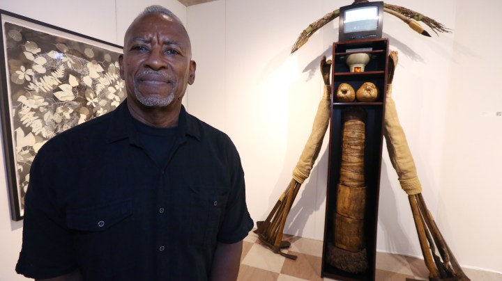 MIAMI, FLORIDA - DECEMBER 03: Puerto Rican artist Daniel Lind-Ramos poses with his assemblage titled "Wardrobe of Conscience, 2013" at the VIP preview of the 2018 PRIZM Art Fair in the Dupont Building on December 3, 2018 in Miami, Florida. (Photo by Sean Drakes/Getty Images)