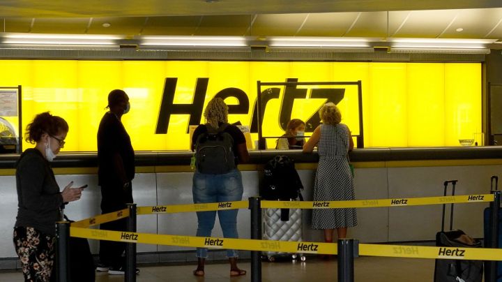 FORT LAUDERDALE, FLORIDA - OCTOBER 25: People stand at a Hertz car rental counter in the Fort Lauderdale-Hollywood International Airport on October 25, 2021 in Miami, Florida. Hertz announced that it ordered 100,000 Teslas as the company is emerging from bankruptcy. (Photo by Joe Raedle/Getty Images)
