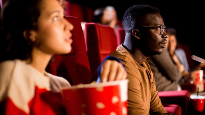 Girl and guy watching a horror movie at the cinema.