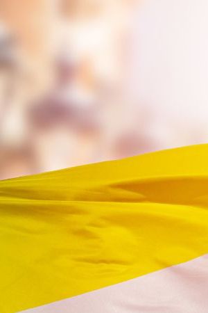 Shot of a non-binary pride flag blowing in the wind at street