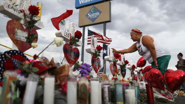 EL PASO, TEXAS - AUGUST 06: A woman touches a cross at a makeshift memorial for victims outside Walmart, near the scene of a mass shooting which left at least 22 people dead, on August 6, 2019 in El Paso, Texas. A 21-year-old white male suspect remains in custody in El Paso, which sits along the U.S.-Mexico border. President Donald Trump plans to visit the city August 7. (Photo by Mario Tama/Getty Images)