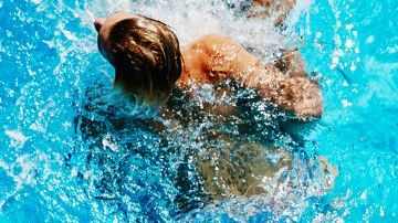 Group of kids playing together in outdoor pool overhead view