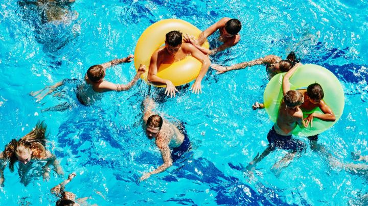 Group of kids playing together in outdoor pool overhead view