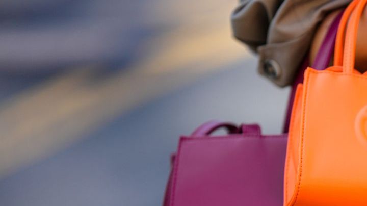 NEW YORK, NEW YORK - SEPTEMBER 14: Samia Laaboudi wears a beige long trench coat, a neon orange shiny leather handbag from Telfar, a burgundy shiny leather large handbag from Telfar, outside Michael Kors, during New York Fashion Week, on September 14, 2022 in New York City. (Photo by Edward Berthelot/Getty Images)
