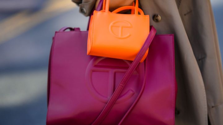 NEW YORK, NEW YORK - SEPTEMBER 14: Samia Laaboudi wears a beige long trench coat, a neon orange shiny leather handbag from Telfar, a burgundy shiny leather large handbag from Telfar, outside Michael Kors, during New York Fashion Week, on September 14, 2022 in New York City. (Photo by Edward Berthelot/Getty Images)