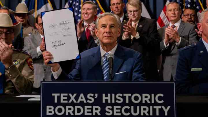 AUSTIN, TEXAS - JUNE 08: Texas Gov. Greg Abbott displays a signed bill during a news conference on June 08, 2023 in Austin, Texas. Gov. Abbott and Texas Department of Public Safety Director Steve McCraw joined bill authors, sponsors, legislators and law enforcement members in the signing of bills designated towards enhancing border security along the southern border. (Photo by Brandon Bell/Getty Images)