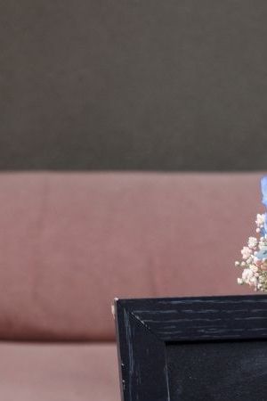 Beautifully set table for a gender reveal party at a rooftop terrace. There are no people since the guests haven't arrived yet. The table is full of delicious sweets and snacks that are waiting for the guests.