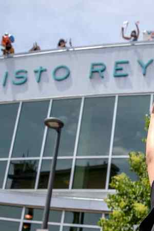 Graduation student waving at school.