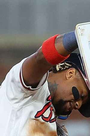 ATLANTA, GEORGIA - SEPTEMBER 27:  Ronald Acuna Jr. #13 of the Atlanta Braves removes second base after stealing it against Dansby Swanson #7 of the Chicago Cubs in the 10th inning at Truist Park on September 27, 2023 in Atlanta, Georgia.  It was Acuna Jr.'s second steal of the night and his 70th steal of the season to make him the first player in MLB history to hit 40 home runs and steal 70 bases in a single season.  (Photo by Kevin C. Cox/Getty Images)