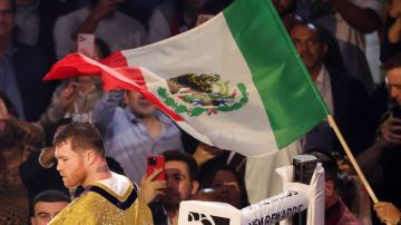 LAS VEGAS, NEVADA - SEPTEMBER 30: A Mexican flag is waved over Canelo Alvarez as he enters the ring for his super middleweight title fight against Jermell Charlo at T-Mobile Arena on September 30, 2023 in Las Vegas, Nevada. Alvarez won by unanimous decision. (Photo by Ethan Miller/Getty Images)