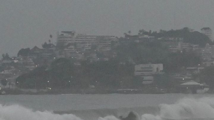 People stand on the beach after Hurricane Otis' arrival alert in Acapulco, Guerrero state, Mexico on October 24, 2023. A new Category 3 hurricane, driven by winds exceeding 200 km/h, threatens Acapulco, the tourist capital of the Pacific on the west coast of Mexico, the American National Hurricane Center (NHC) said on Tuesday. (Photo by FRANCISCO ROBLES / AFP) (Photo by FRANCISCO ROBLES/AFP via Getty Images)
