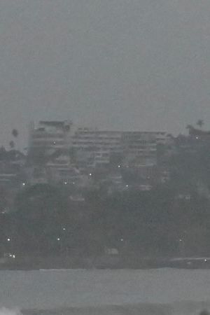 People stand on the beach after Hurricane Otis' arrival alert in Acapulco, Guerrero state, Mexico on October 24, 2023. A new Category 3 hurricane, driven by winds exceeding 200 km/h, threatens Acapulco, the tourist capital of the Pacific on the west coast of Mexico, the American National Hurricane Center (NHC) said on Tuesday. (Photo by FRANCISCO ROBLES / AFP) (Photo by FRANCISCO ROBLES/AFP via Getty Images)