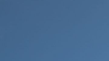 Bottom View of Passenger Airplane Flying Over Waving Mexico Flag On Pole.