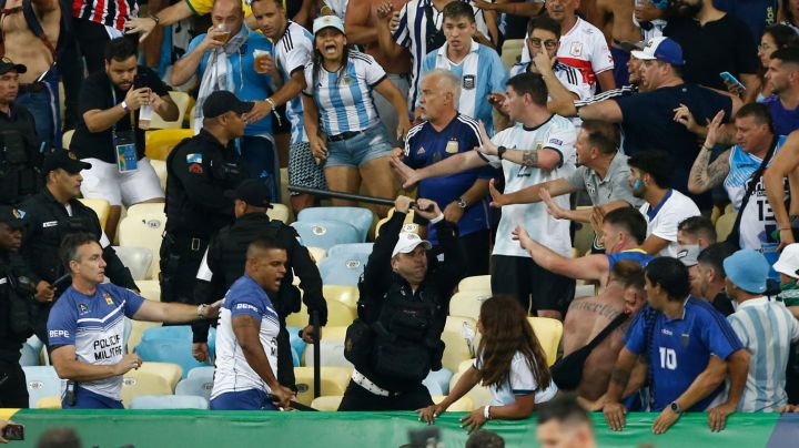 RIO DE JANEIRO, BRAZIL - NOVEMBER 21: Police officers armed with batons clash with fans as the match is delayed due to the incidents prior to a FIFA World Cup 2026 Qualifier match between Brazil and Argentina at Maracana Stadium on November 21, 2023 in Rio de Janeiro, Brazil. (Photo by Wagner Meier/Getty Images)