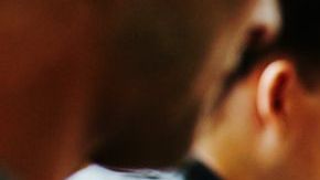 Waitress pouring wine into glass at table in restaurant