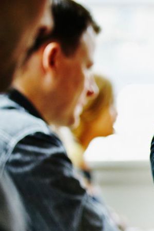 Waitress pouring wine into glass at table in restaurant