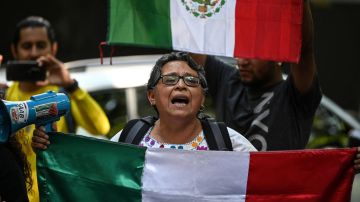People holding Mexican flags protest outside the Ecuadorian embassy in Mexico City on April 6, 2024, following the severance of diplomatic relations between the Ecuador and Mexico. Ecuadorian authorities stormed the Mexican embassy in Quito on April 5 to arrest former vice president Jorge Glas, who had been granted political asylum there, prompting Mexico to sever diplomatic ties after the "violation of international law". (Photo by Yuri CORTEZ / AFP) (Photo by YURI CORTEZ/AFP via Getty Images)