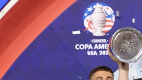 Argentina's forward #10 Lionel Messi lifts up the trophy.