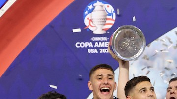 Argentina's forward #10 Lionel Messi lifts up the trophy.