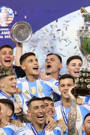 Argentina's forward #10 Lionel Messi lifts up the trophy.