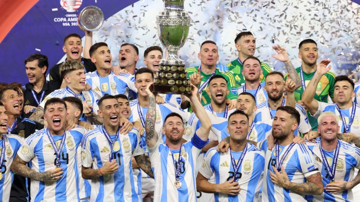 Argentina's forward #10 Lionel Messi lifts up the trophy.