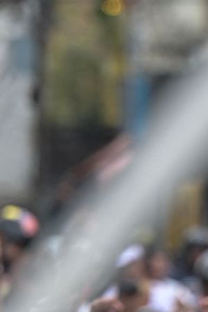 Police officers stand guard next to demonstrators waving Venezuelan flags during a protest against Venezuelan President Nicolas Maduro's government in Caracas on July 29, 2024, a day after the Venezuelan presidential election. Protests erupted in parts of Caracas Monday against the re-election victory claimed by Venezuelan President Nicolas Maduro but disputed by the opposition and questioned internationally, AFP journalists observed. (Photo by Yuri CORTEZ / AFP) (Photo by YURI CORTEZ/AFP via Getty Images)