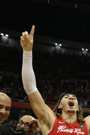 Puerto Rico's players celebrate with the ticket to the 2024 Paris Olympics after defeating Lithuania during the 2024 FIBA Men's Olympic Qualifying Tournament basketball match in San Juan, Puerto Rico, on July 7, 2024. (Photo by Ricardo ARDUENGO / AFP) (Photo by RICARDO ARDUENGO/AFP via Getty Images)