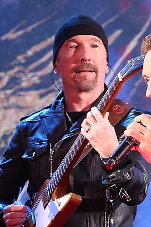 NEW YORK, NY - DECEMBER 01:  The Edge and Chris Martin of Coldplay perform as "U2 - 1" in a surprise concert by (RED) to mark World AIDS Day in Times Square on December 1, 2014 in New York City.  (Photo by Taylor Hill/FilmMagic)