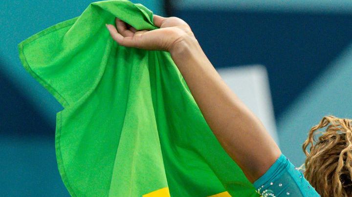 PARIS, FRANCE - AUGUST 5: Gold medal winner Rebeca Andrade of Brazil celebrates with the brazilian flag while women´s floor exercise final on day ten of the Olympic Games Paris 2024 at Bercy Arena on August 05, 2024 in Paris, France. (Photo by Rodolfo Buhrer/Eurasia Sport Images/Getty Images)
