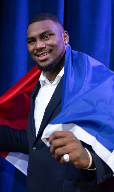 DETROIT, MICHIGAN - APRIL 27: Bayron Matos poses with the flag of the Dominican Republic during day 3 of the NFL Draft at Campus Martius Park and Hart Plaza on April 27, 2024 in Detroit, Michigan. (Photo by Luke Hales/Getty Images)