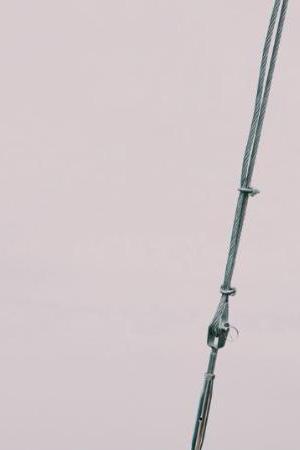 Beautiful shot of a bow of the boat on the sea with hills and a cloudy in the background