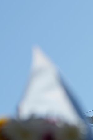 Flags, flowers and other tributes are left on a fence near the Cuauhtemoc, a masted Mexican Navy training ship, after it collided with the Brooklyn Bridge in New York, Monday, May 19, 2025. (AP Photo/Seth Wenig)