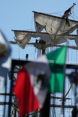 Flags, flowers and other tributes are left on a fence near the Cuauhtemoc, a masted Mexican Navy training ship, after it collided with the Brooklyn Bridge in New York, Monday, May 19, 2025. (AP Photo/Seth Wenig)