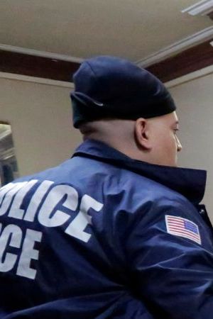 In this March 3, 2015 photo, Immigration and Customs Enforcement officers escort an arrestee in an apartment building, in the Bronx borough of New York, during a series of early-morning raids. Immigrant and Customs Enforcement say an increasing number of cities and counties across the United States are limiting cooperation with the agency and putting its officers in dangerous situations as they track down foreign-born criminals. Instead, more of its force is out on the streets, eating up resources and conducting investigations because cities like New York and states like California have passed legislation that limits many of the detention requests issued by immigration authorities. (AP Photo/Richard Drew)