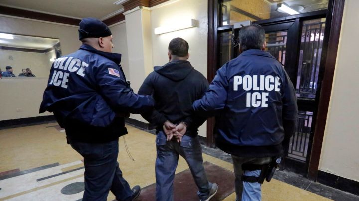 In this March 3, 2015 photo, Immigration and Customs Enforcement officers escort an arrestee in an apartment building, in the Bronx borough of New York, during a series of early-morning raids. Immigrant and Customs Enforcement say an increasing number of cities and counties across the United States are limiting cooperation with the agency and putting its officers in dangerous situations as they track down foreign-born criminals. Instead, more of its force is out on the streets, eating up resources and conducting investigations because cities like New York and states like California have passed legislation that limits many of the detention requests issued by immigration authorities. (AP Photo/Richard Drew)