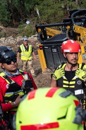 A crew of firefighters from Ciudad Acuna, Mexico, gather for a briefing as they aid in search and rescue efforts near the Guadalupe River after a flash flood swept through the area Monday, July 7, 2025, in Ingram, Texas. (AP Photo/Eli Hartman)