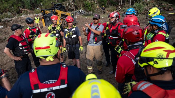 A crew of firefighters from Ciudad Acuna, Mexico, gather for a briefing as they aid in search and rescue efforts near the Guadalupe River after a flash flood swept through the area Monday, July 7, 2025, in Ingram, Texas. (AP Photo/Eli Hartman)