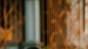 Dancer with a flowing green skirt pictured in the middle with drummers to her right and spectators to her left for La Sala Libre