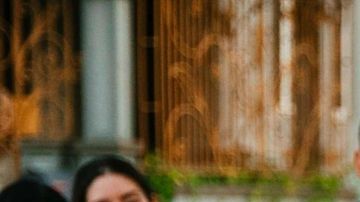 Dancer with a flowing green skirt pictured in the middle with drummers to her right and spectators to her left for La Sala Libre
