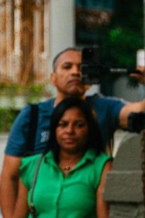 Dancer with a flowing green skirt pictured in the middle with drummers to her right and spectators to her left for La Sala Libre